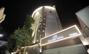 un edificio alto con un cartel delante en February Hotel SeongSeo en Daegu