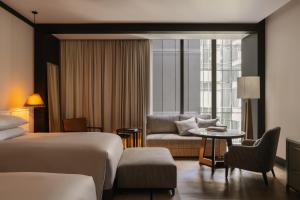 シドニーにあるCapella Sydneyのベッドとソファ付きのホテルルーム