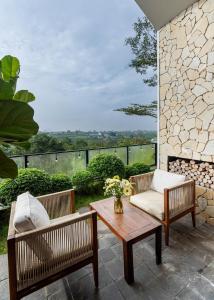 eine Terrasse mit 2 Stühlen und einem Couchtisch in der Unterkunft THE MYST VILLA BAO LOC in Ấp Tân Hà