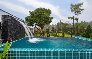a swimming pool with a fountain in a yard at THE MYST VILLA BAO LOC in Ấp Tân Hà