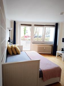 um quarto com uma cama com almofadas e uma janela em Apartment am Bach em Augsburg