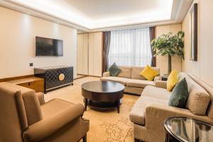 a living room with couches and a table at Maoming International Hotel in Maoming