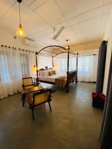 a bedroom with a bed and a table in a room at Happy Valley Residence Unawatuna in Galle
