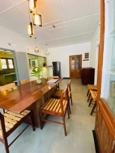 a dining room with a large wooden table and chairs at Happy Valley Residence Unawatuna in Galle