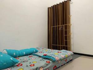 um quarto com uma cama com um edredão azul em Villa di Malang Dekat Kampus Ternama em Malang