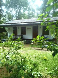 a small white house in the middle of a yard at Sigiriya Hillside View Villa in Sigiriya