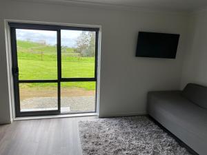 a room with a bed and a window with a view of a field at Rural Guest Studio 