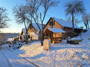 una casa con nieve en el suelo junto a una calle en Macskajaj vendégház, en Mecseknádasd