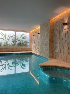 Misk Villa - Boutique Hotel & Spa في سيدي بو سعيد: مسبح في مبنى مع نافذة كبيرة