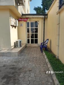 Winstons Place Hotel في Onitsha: كرسي ازرق جالس امام مبنى
