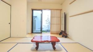 ein Zimmer mit einem Tisch in der Mitte eines Zimmers in der Unterkunft 知輪-chirin- in Sakai