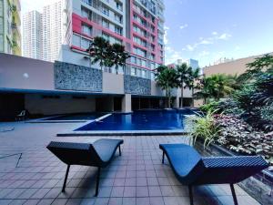 a courtyard with two chairs and a swimming pool at Condotel at Sunshine100 Mandaluyong City near EDSA in Manila