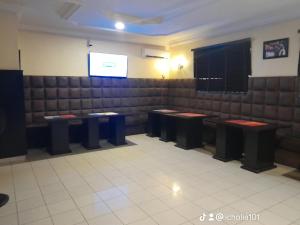una sala de espera con bancos y una pantalla en Winstons Place Hotel, en Onitsha
