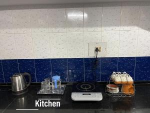 a kitchen with blue and white tile on the wall at Sai Homestay Goa - Margao in Madgaon