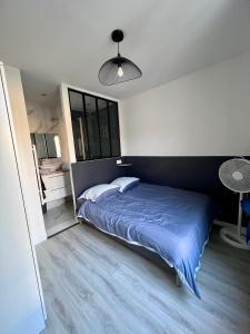 - une chambre avec un grand lit et une couverture bleue dans l'établissement AUBERVILLIERS COSY, à Aubervilliers