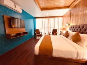 馬拉里的住宿－TATA Vista Resort Mall Road Manali - Centrally Heated & Air Cooled，酒店客房,配有床和电视