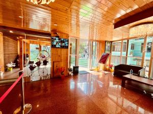 TATA Vista Resort Mall Road Manali - Centrally Heated & Air Cooled في مانالي: غرفة معيشة مع أريكة وطاولة