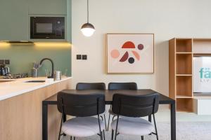 a kitchen with a black table and four chairs at Upside Living - City Escape - WFH Friendly-Business Bay in Dubai