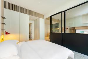 a bedroom with a white bed and glass walls at FAM Living - Upside Living - WFH Friendly-Business Bay in Dubai +120 photos