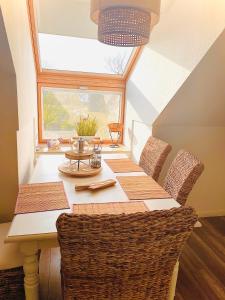 ein Esszimmer mit einem Tisch mit Stühlen und einem Fenster in der Unterkunft Weidelandfarm am Riebener See in Beelitz