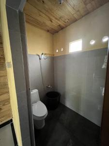 a small bathroom with a toilet and a window at Ulina Villa Lokan B Berastagi in Berastagi