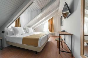 a bedroom with a large bed in a attic at Hotel Viella in Vielha