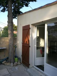 a door to a house with a tree next to it at Maisonnette avec terrasse Marseille 9ème in Marseille