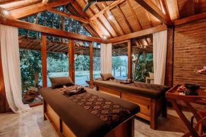 two beds in a room with a large window at ZIN Canggu Resort & Villas in Canggu