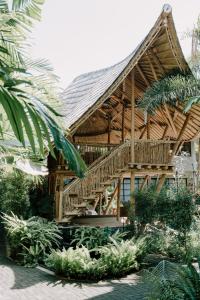 uma casa de madeira com uma escada em frente em ZIN Canggu Resort & Villas em Canggu