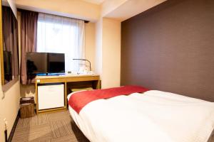 草津市にあるラックホテル草津のベッドルーム1室(ベッド1台、デスク、テレビ付)