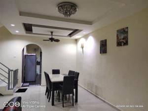 uma sala de jantar com uma mesa e cadeiras pretas em Kulim Square Homestay em Lunas