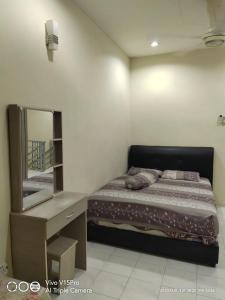 um quarto com uma cama, uma cómoda e um espelho em Kulim Square Homestay em Lunas