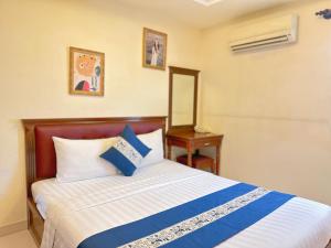 a bedroom with a bed and a table and a mirror at Kim Dung Hotel Tran Quang Khai in Ho Chi Minh City