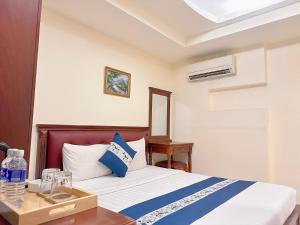 Un dormitorio con una cama y una mesa con una botella de agua. en Kim Dung Hotel Tran Quang Khai, en Ho Chi Minh