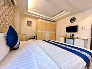 een slaapkamer met een groot wit bed en een televisie bij Kim Dung Hotel Tran Quang Khai in Ho Chi Minh-stad