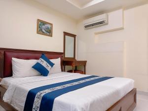 胡志明市Kim Dung Hotel Tran Quang Khai的卧室里有一张大床，配有蓝白相间的枕头 更多21张照片