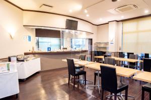 草津市にあるラックホテル草津のテーブルと椅子、カウンター付きのレストラン