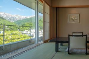 a room with a table and a view of mountains at Zazan minakami in Minakami