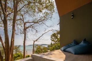 a room with a bed with a view of the ocean at Nature Vista Rawai in Nai Harn Beach