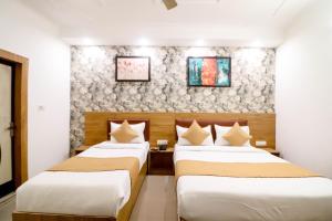 two beds in a hotel room next to each other at Hotel Stay Villa Near Delhi Airport in New Delhi