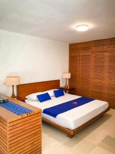 ein Schlafzimmer mit einem großen Bett mit blauen Kissen in der Unterkunft The Ikat Villa in Ubud