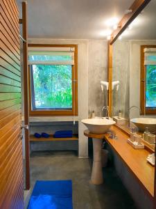 ein Bad mit 2 Waschbecken und einem Fenster in der Unterkunft The Ikat Villa in Ubud