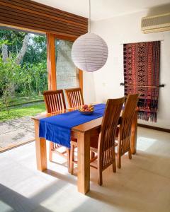 ein Esszimmer mit einem blauen Tisch und Stühlen in der Unterkunft The Ikat Villa in Ubud