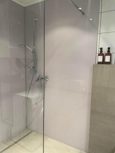 a shower with a glass door and two bottles of soap at Ferienwohnung Achenrain 1 in Kramsach