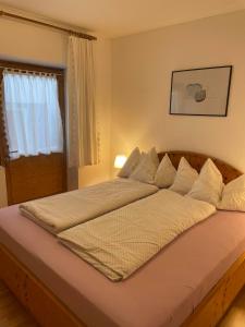 a bedroom with a large bed with white sheets at Ferienwohnung Achenrain 1 in Kramsach