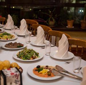 einen Tisch mit Teller mit Lebensmitteln darüber in der Unterkunft Alma in Almaty
