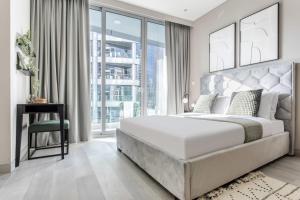 a bedroom with a large white bed and a desk at Frank Porter - Marina Star in Dubai
