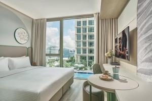 新加坡Citadines Science Park Singapore的酒店客房设有一张大床和一张桌子