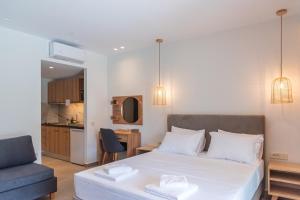 a bedroom with a white bed and a blue chair at IL Mare Plataria in Plataria