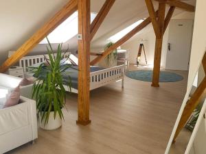 a attic room with a bed and some plants at Ferienhaus Engelsberghof in Endingen